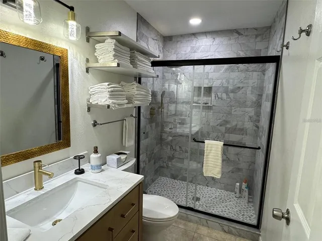 a bathroom with a sink a toilet and shower