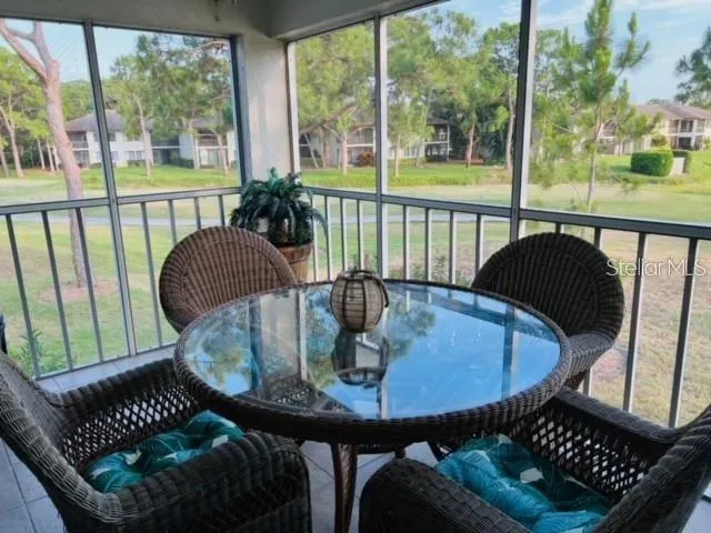 a dining room with furniture a rug and a floor to ceiling window