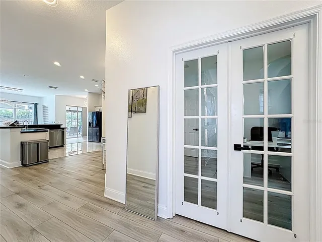 a dining room with stainless steel appliances kitchen island granite countertop a dining table chairs and a refrigerator