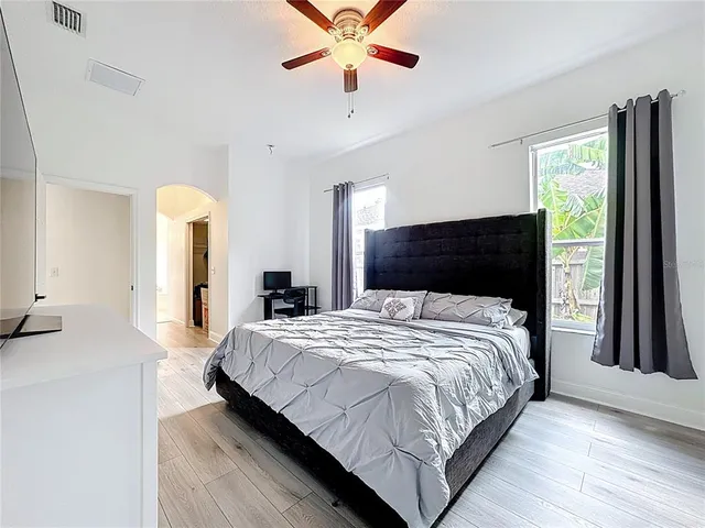 a bedroom with a bed and a flat tv screen on a dresser