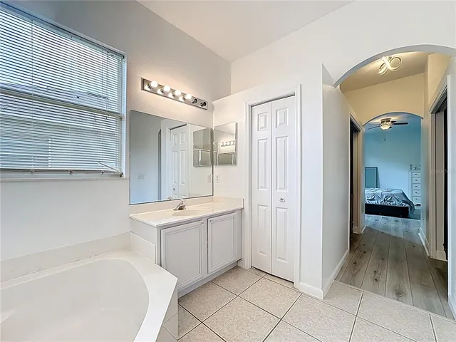 a bathroom with a tub sink and mirror