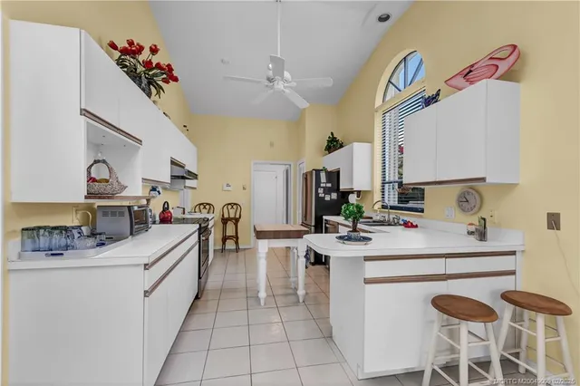 a kitchen filled with white cabinets appliances and furniture