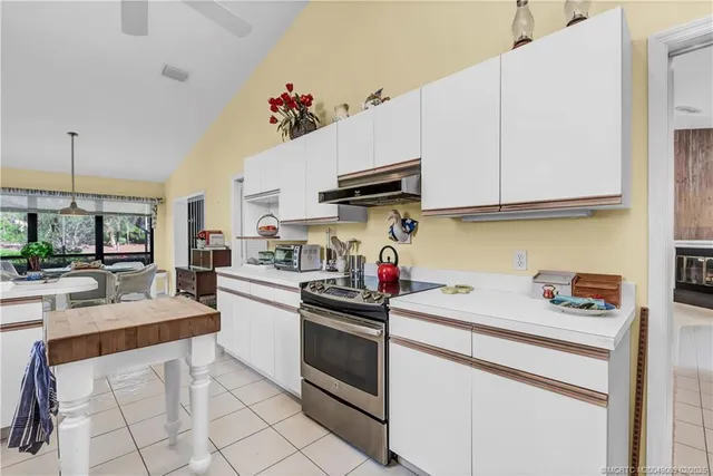 a kitchen with granite countertop a sink stainless steel appliances and white cabinets