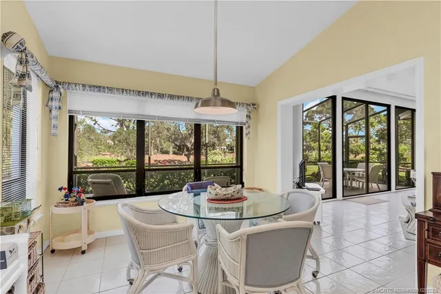 a dining room with furniture large windows and wooden floor