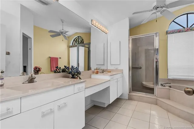 a bathroom with a double vanity sink mirror and bathtub
