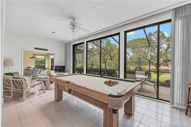 a room with pool table and large windows