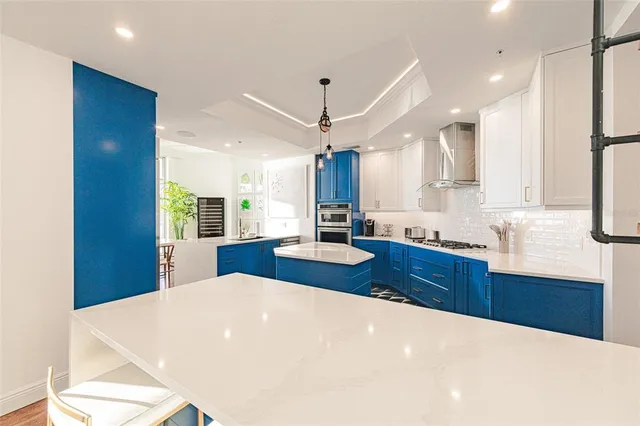 a large kitchen with stainless steel appliances kitchen island granite countertop a sink refrigerator and cabinets