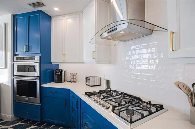 a large living room with stainless steel appliances kitchen island granite countertop furniture and a fireplace