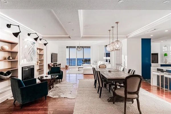 a view of a dining room with furniture a chandelier and wooden floor