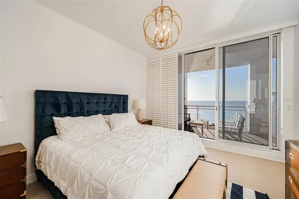 a bedroom with a bed and a chandelier