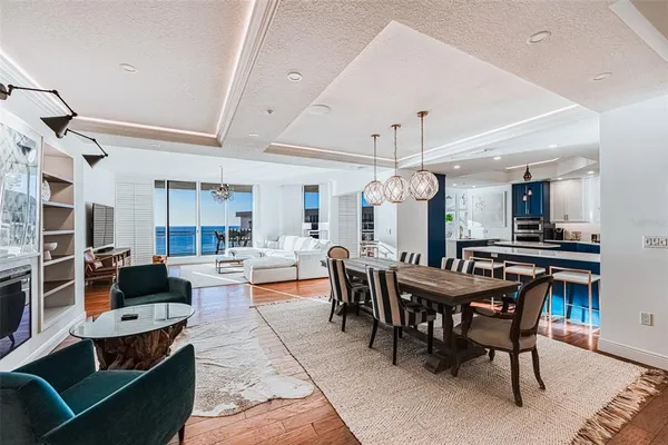 a view of a dining room with furniture a chandelier and wooden floor