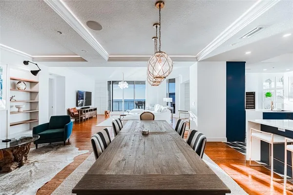 a living room with furniture large window and wooden floor