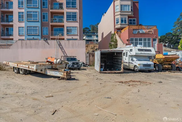 a front view of a building with cars parked