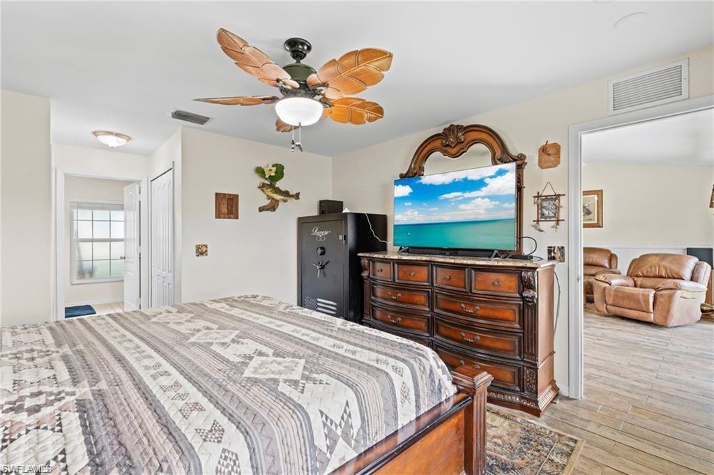 3303 32nd Street Southwest Lehigh Acres, FL 33976 - Photo 10 of 35 a bedroom with a bed and a chandelier