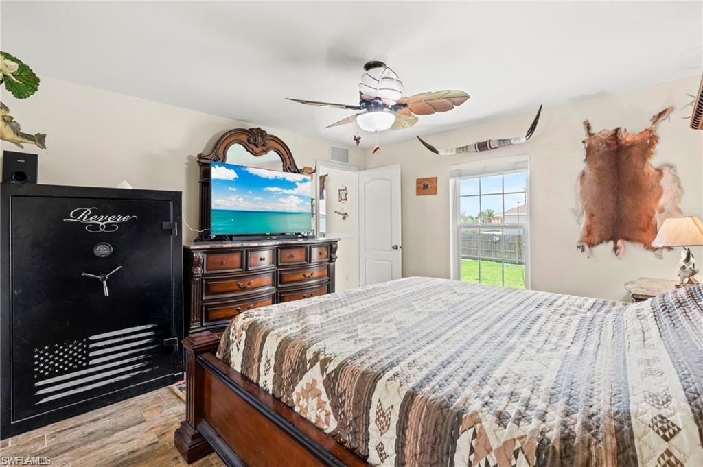 3303 32nd Street Southwest Lehigh Acres, FL 33976 - Photo 11 of 35 a bedroom with a bed and a chandelier