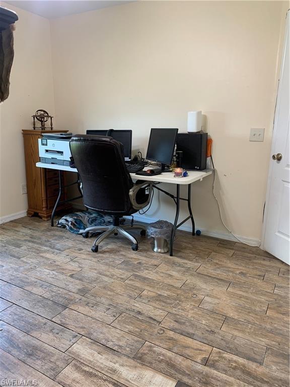 3303 32nd Street Southwest Lehigh Acres, FL 33976 - Photo 19 of 35 a work room with furniture and wooden floor