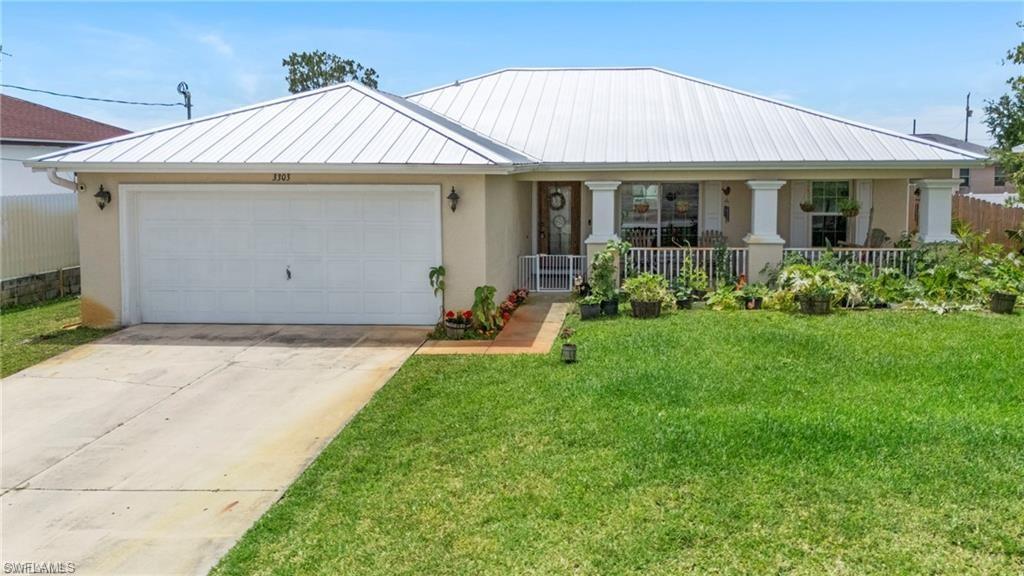 3303 32nd Street Southwest Lehigh Acres, FL 33976 - Photo 2 of 35 a front view of a house with garden
