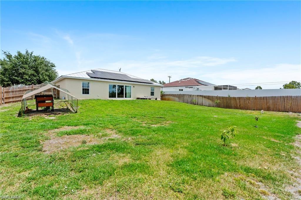 3303 32nd Street Southwest Lehigh Acres, FL 33976 - Photo 23 of 35 a view of house with backyard and outdoor seating