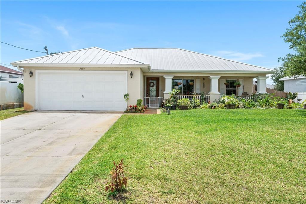 3303 32nd Street Southwest Lehigh Acres, FL 33976 - Photo 27 of 35 a front view of a house with garden