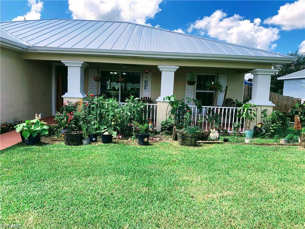 3303 32nd Street Southwest Lehigh Acres, FL 33976 - Photo 28 of 35 a front view of a house with a garden