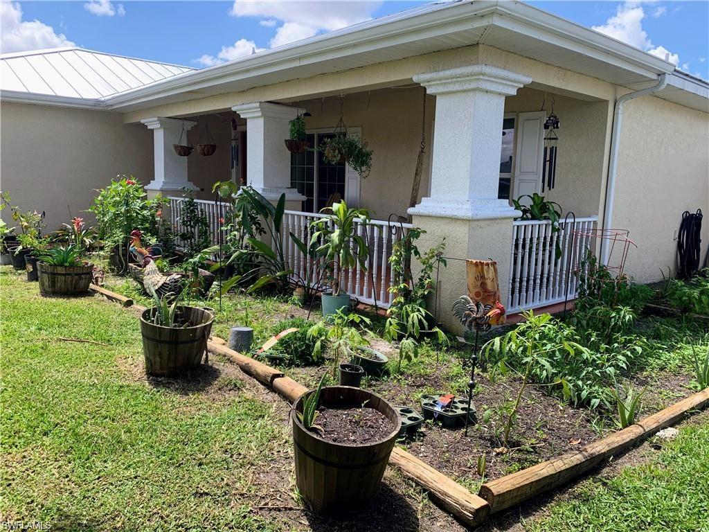 3303 32nd Street Southwest Lehigh Acres, FL 33976 - Photo 31 of 35 a front view of a house with garden and plants