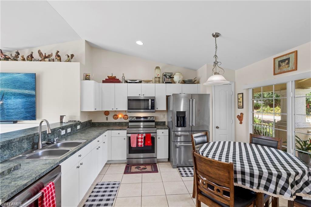 3303 32nd Street Southwest Lehigh Acres, FL 33976 - Photo 5 of 35 a kitchen with stainless steel appliances kitchen island granite countertop a stove a sink and a refrigerator