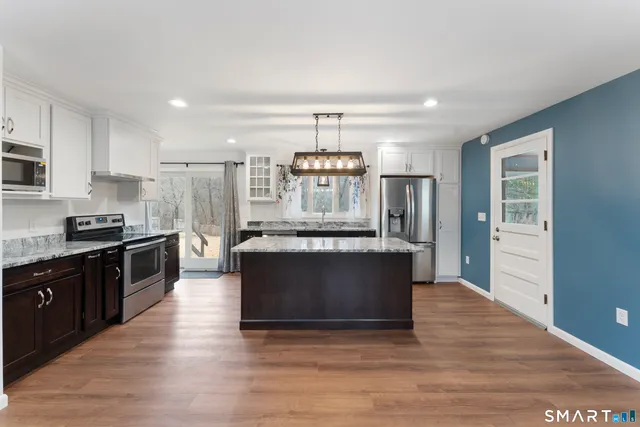 a kitchen with stainless steel appliances granite countertop a stove and a refrigerator