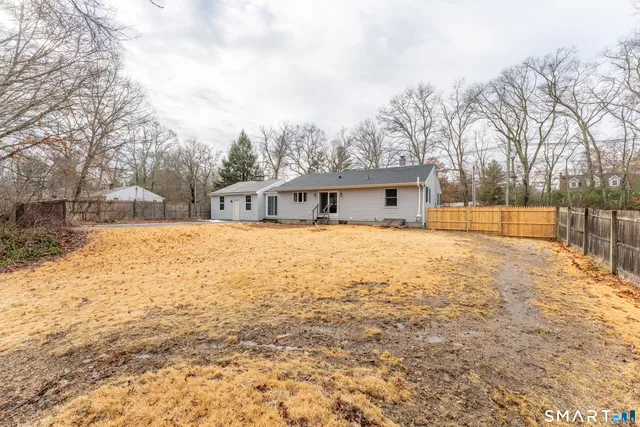 a view of house with yard and sitting area
