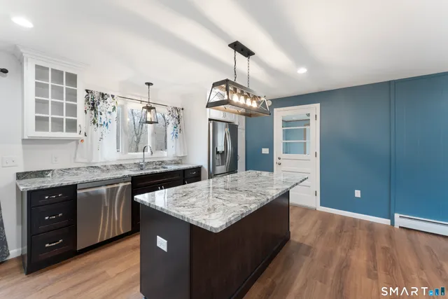 a kitchen with granite countertop a stove and a wooden floors