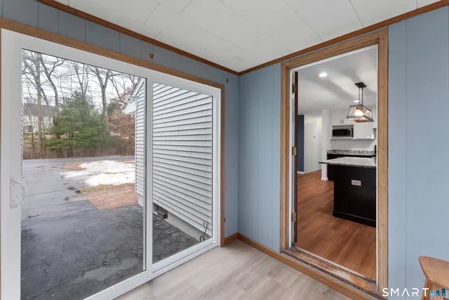 a view of a hallway with wooden floor and a living room