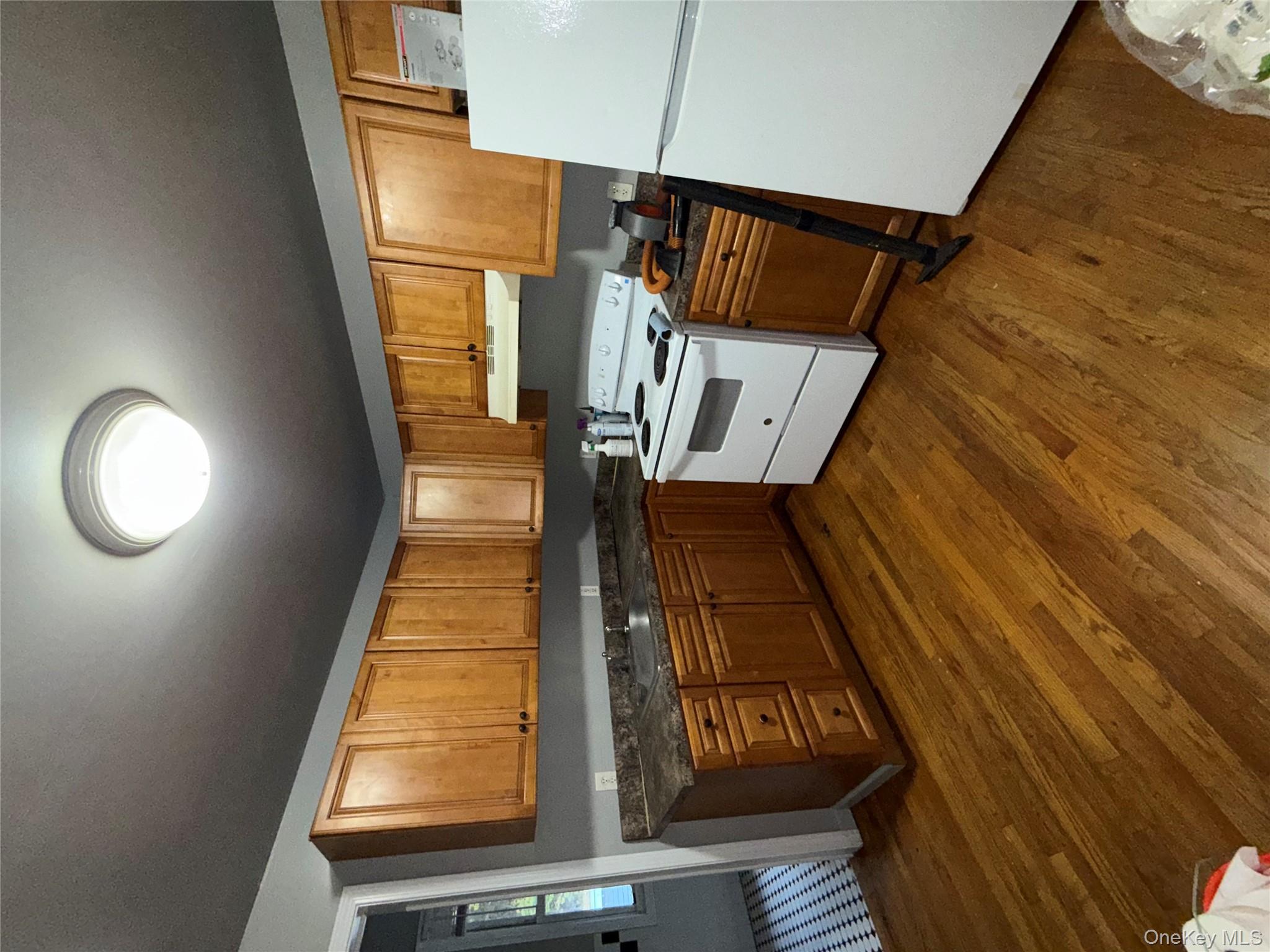 54 Gifford Avenue, Unit 2 Poughkeepsie, NY 12601 - Photo 11 of 19 a kitchen with wooden floors and white appliances