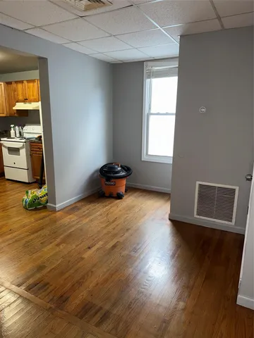 a view of empty room with wooden floor