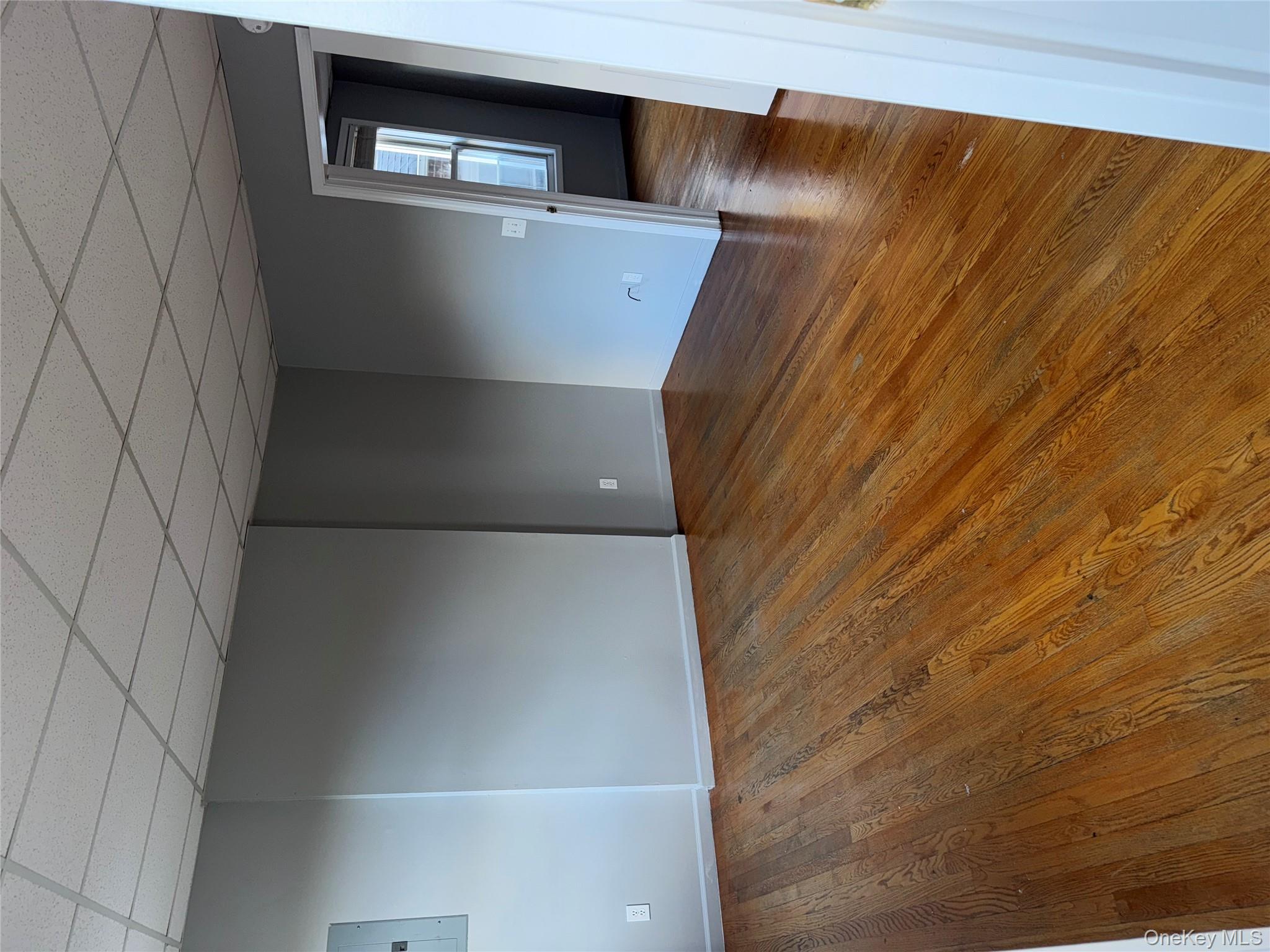 54 Gifford Avenue, Unit 2 Poughkeepsie, NY 12601 - Photo 8 of 19 a view of an empty room with wooden floor and a window