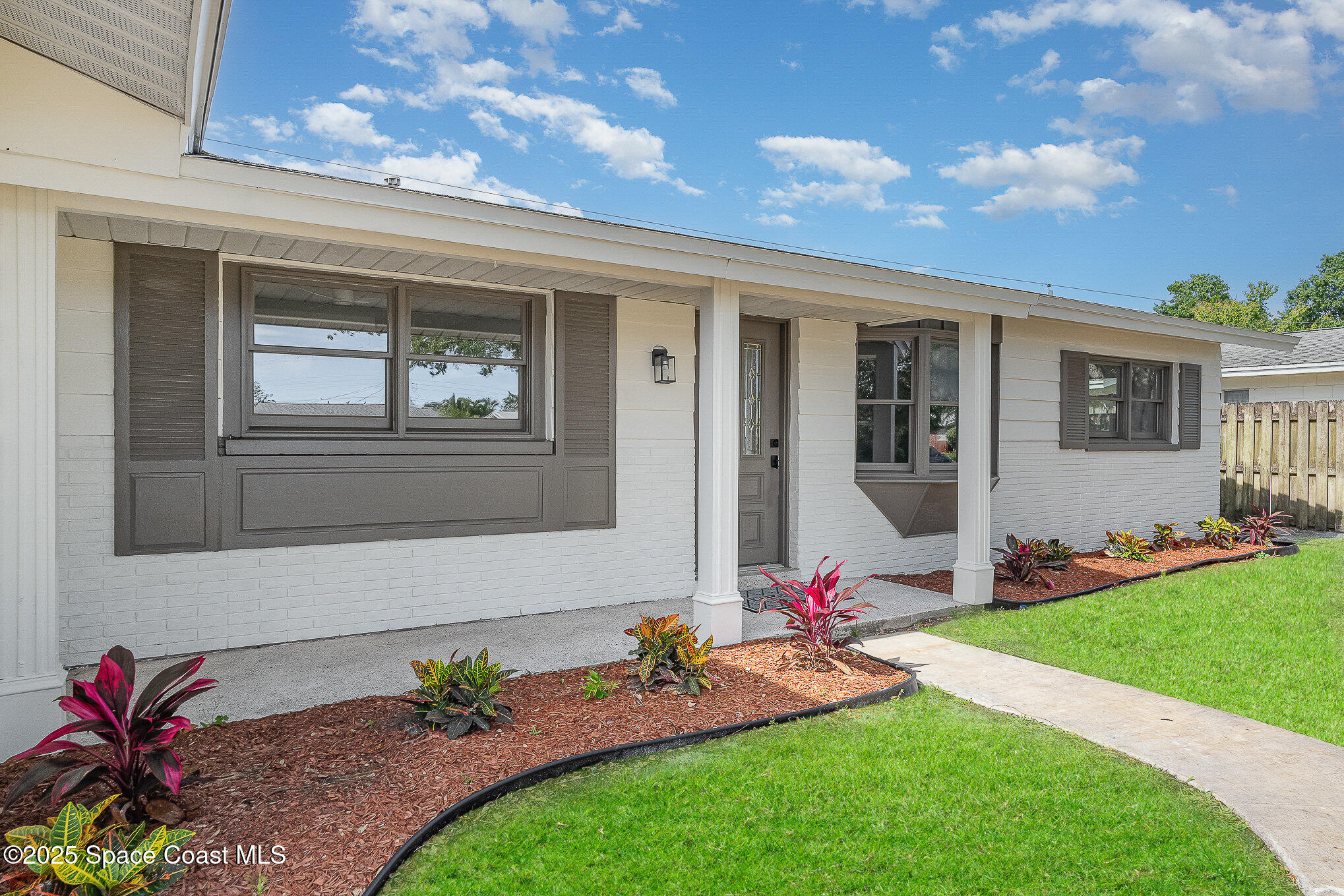 a backyard of a house with table and chairs