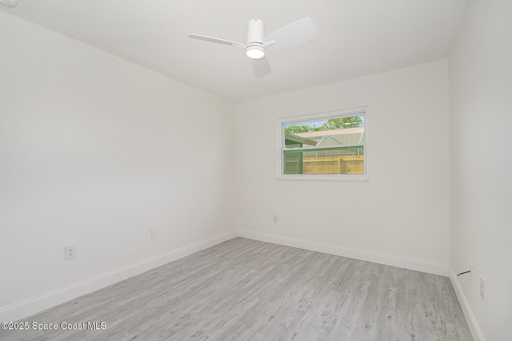 906 Kings Post Road Rockledge, FL 32955 - Photo 17 of 31 an empty room with wooden floor and windows