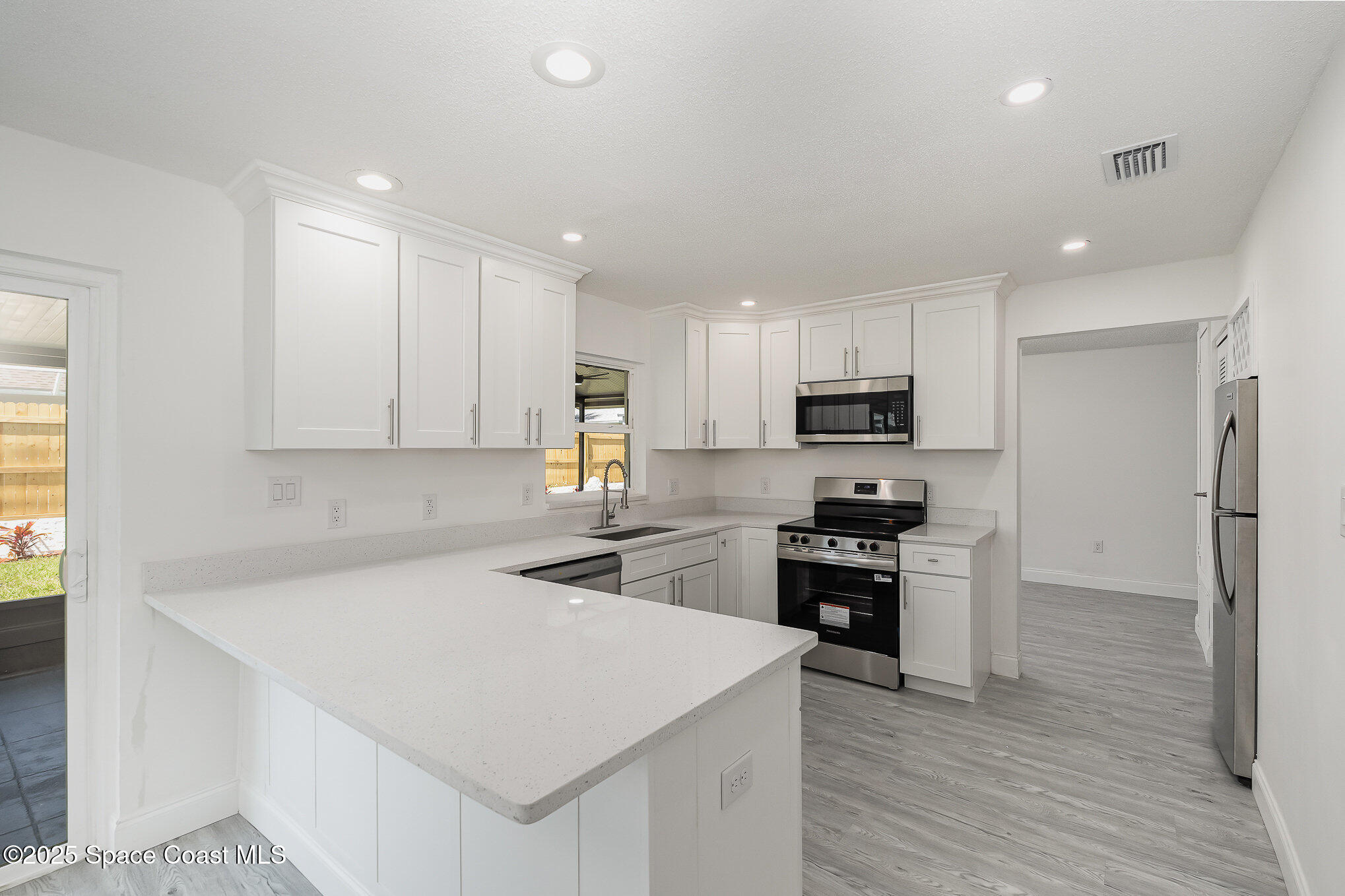 906 Kings Post Road Rockledge, FL 32955 - Photo 2 of 31 a kitchen with granite countertop white cabinets and stainless steel appliances