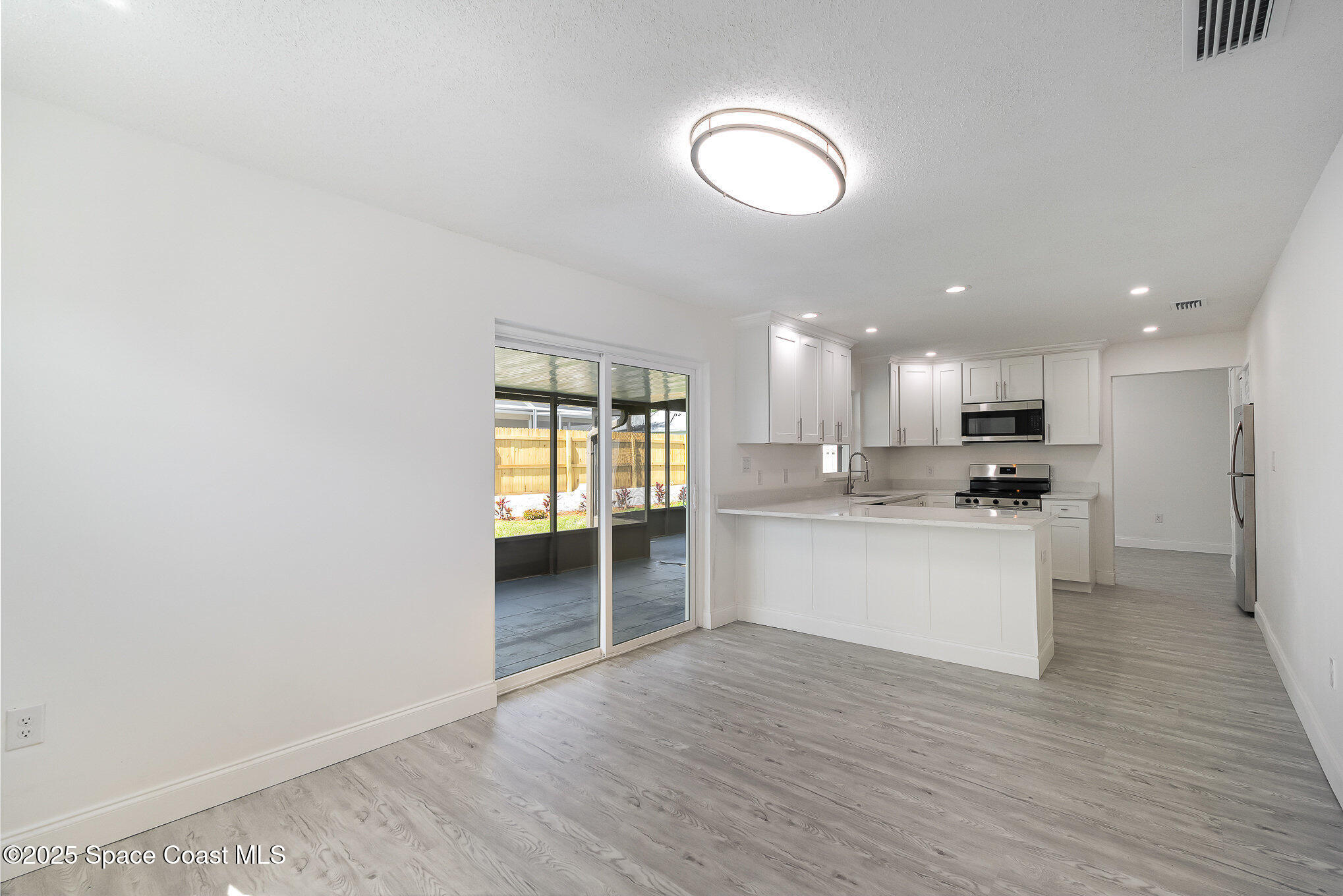 906 Kings Post Road Rockledge, FL 32955 - Photo 4 of 31 a kitchen with a refrigerator and a microwave