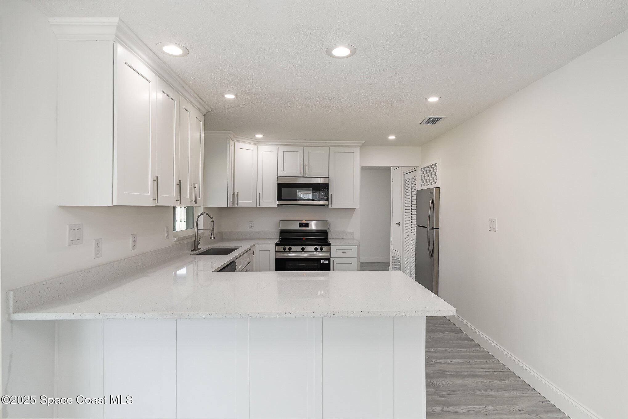906 Kings Post Road Rockledge, FL 32955 - Photo 5 of 31 a kitchen with stainless steel appliances a refrigerator sink and microwave