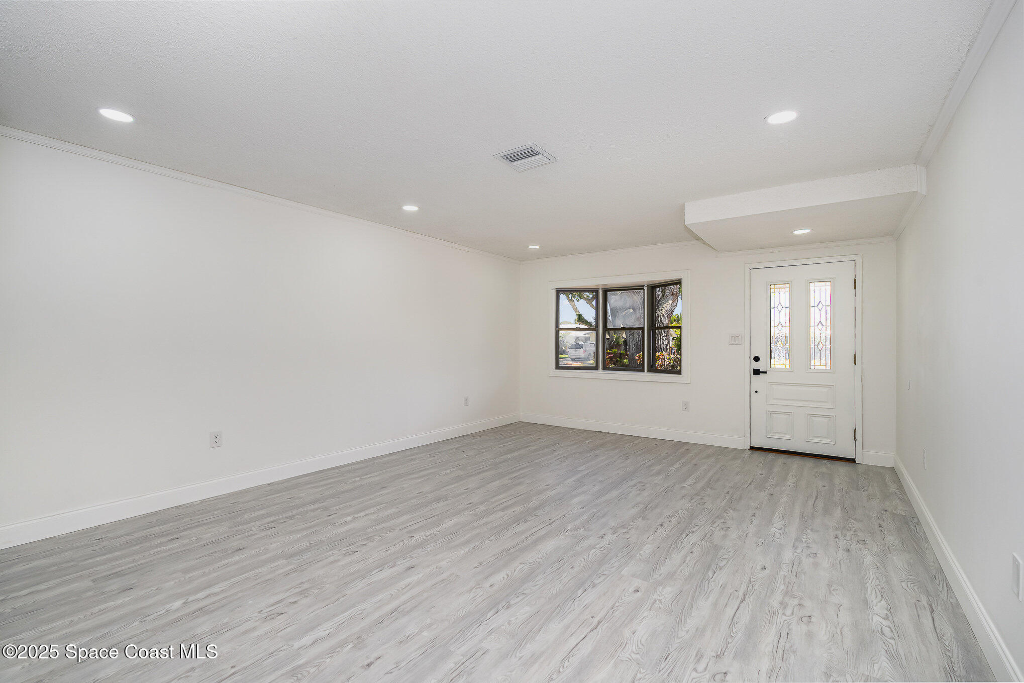 906 Kings Post Road Rockledge, FL 32955 - Photo 6 of 31 an empty room with wooden floor and windows