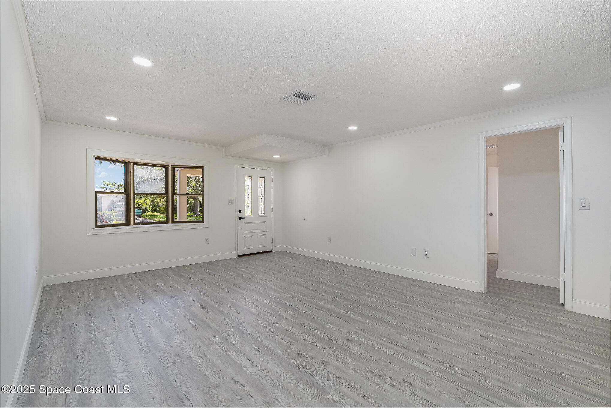 906 Kings Post Road Rockledge, FL 32955 - Photo 9 of 31 an empty room with wooden floor and windows