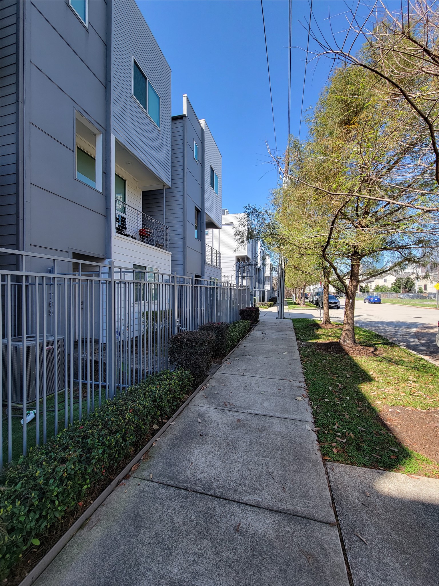 1705 Eado Point Lane Houston, TX 77003 - Photo 3 of 50 Modern townhouse exterior with a sleek design, featuring a fenced front area and a tree-lined sidewalk, providing a pleasant, urban neighborhood feel. Great for walks and walking pets.