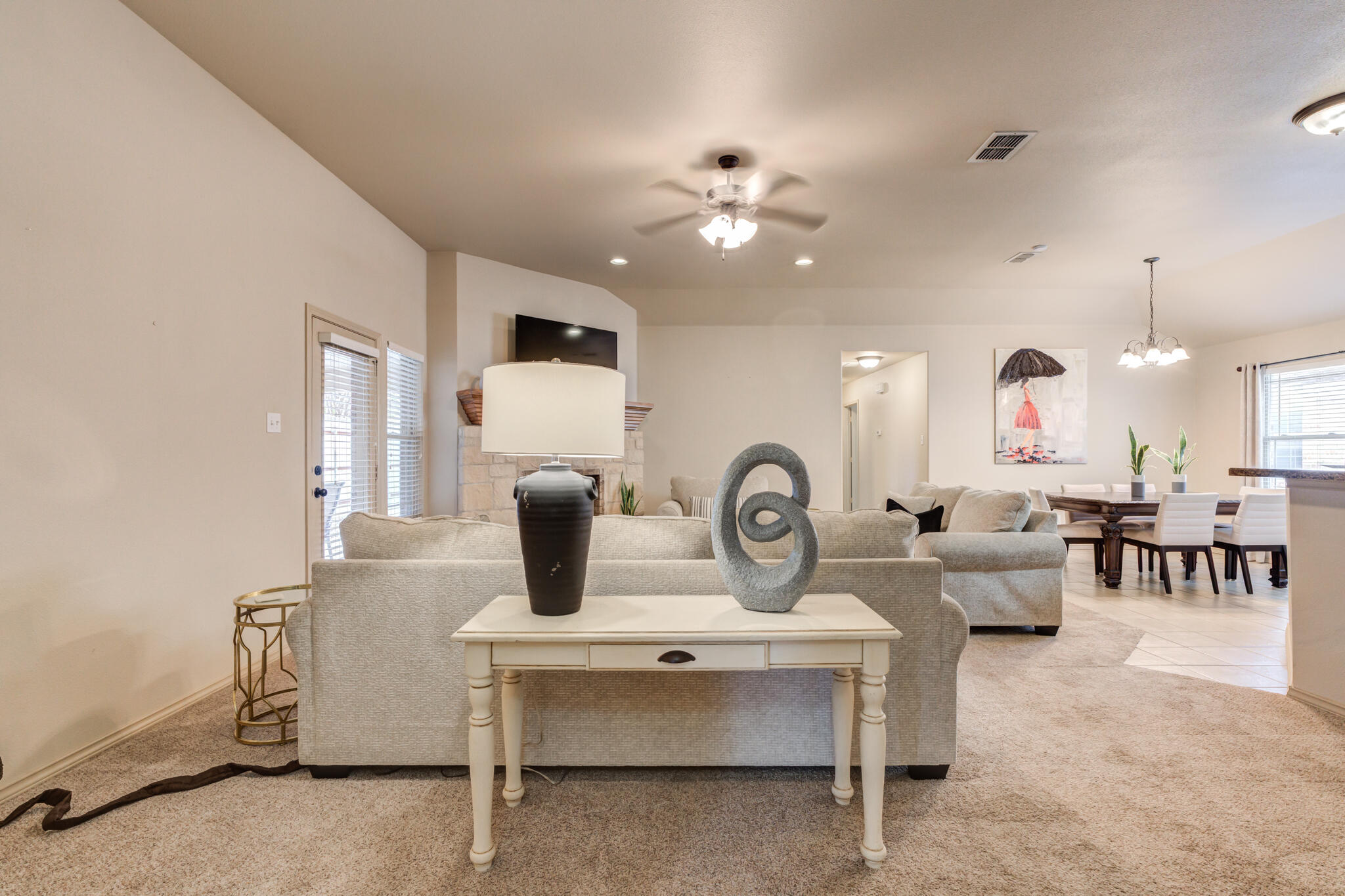2206 101st Street Lubbock, TX 79423 - Photo 11 of 37 a living room with furniture a chandelier fan and a window