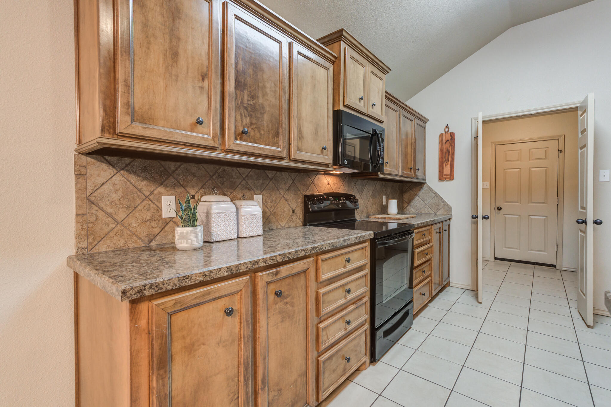 2206 101st Street Lubbock, TX 79423 - Photo 20 of 37 a kitchen with stainless steel appliances granite countertop a sink stove and cabinets