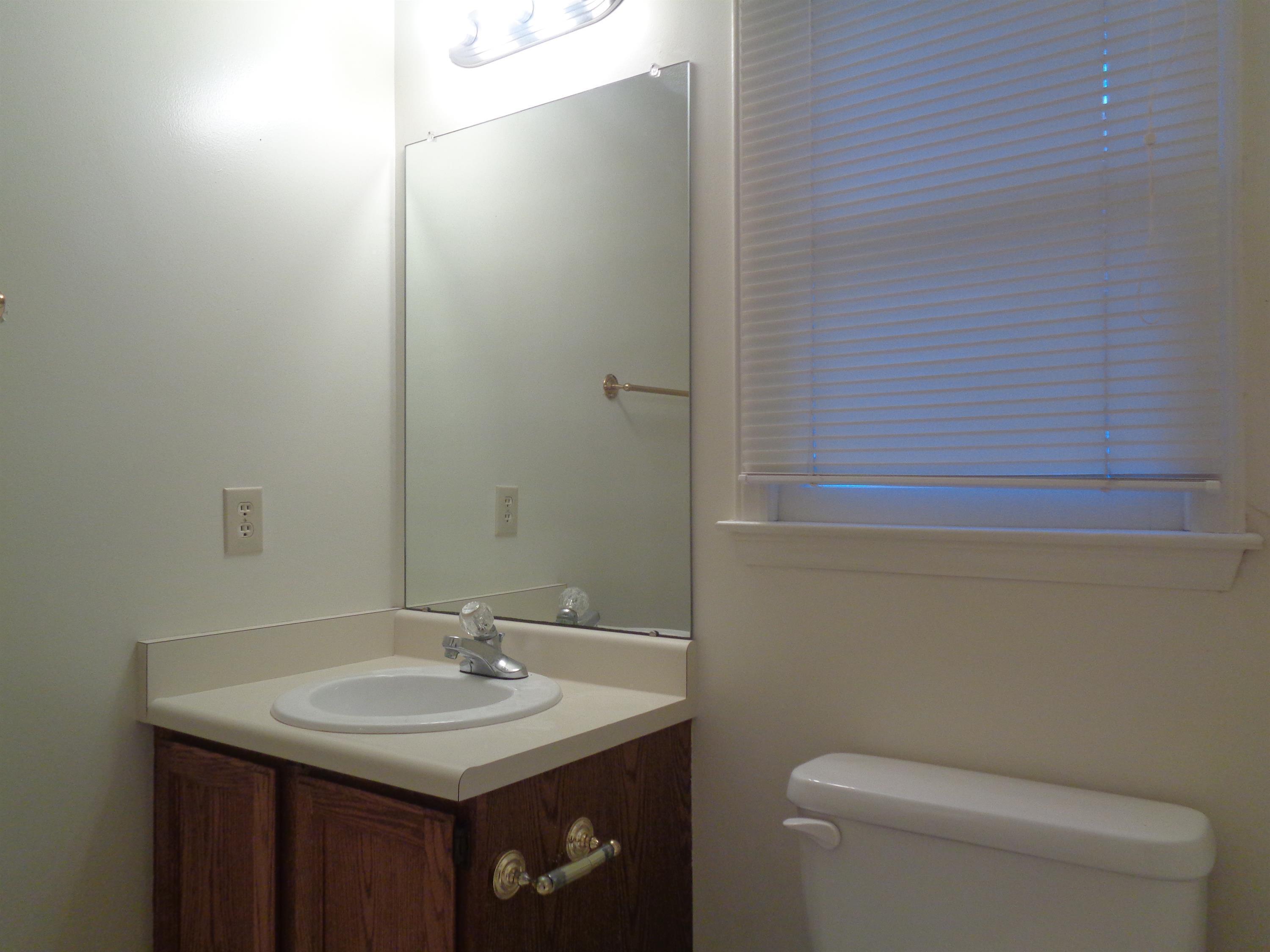 2704 Moorsfield Court Raleigh, NC 27604 - Photo 14 of 25 a bathroom with a granite countertop sink a toilet and a mirror