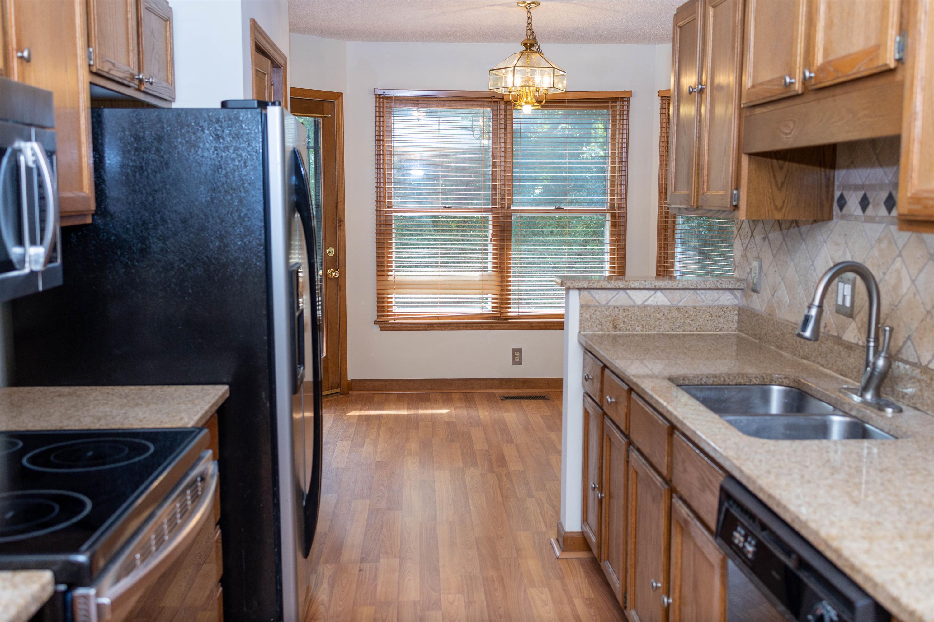 2704 Moorsfield Court Raleigh, NC 27604 - Photo 5 of 25 a kitchen with stainless steel appliances granite countertop a sink stove and refrigerator