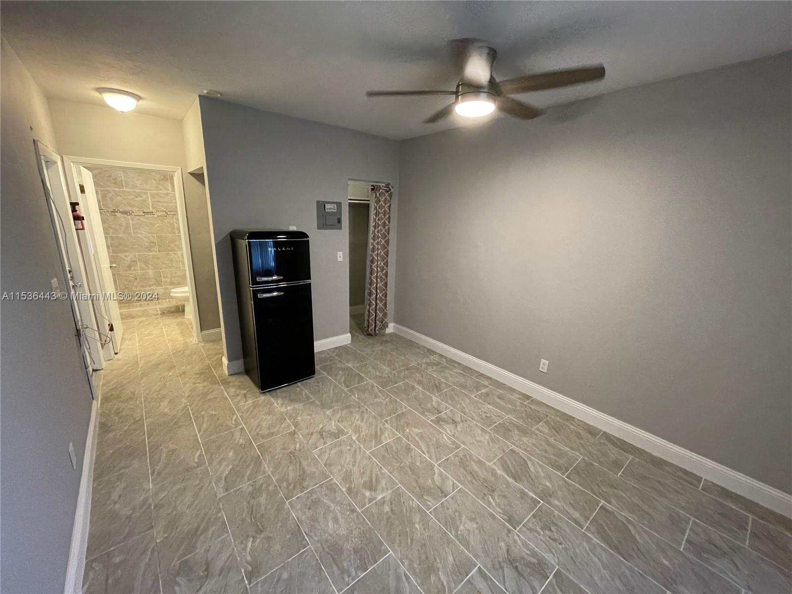 an empty room with closet and a ceiling fan