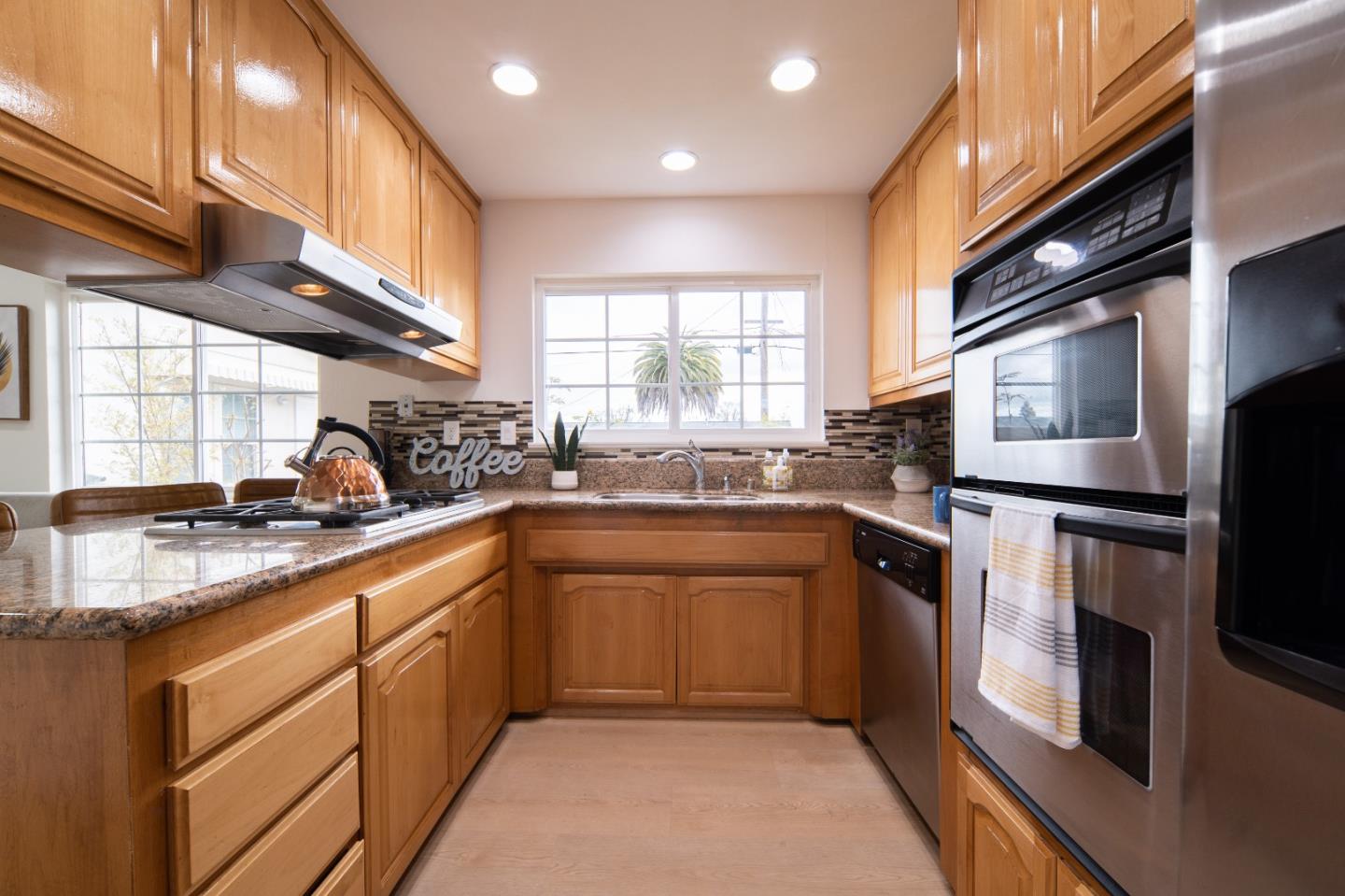 8567 Galindo Drive Dublin, CA 94568 - Photo 29 of 41 a kitchen with stainless steel appliances granite countertop a sink a stove a refrigerator cabinets and a window