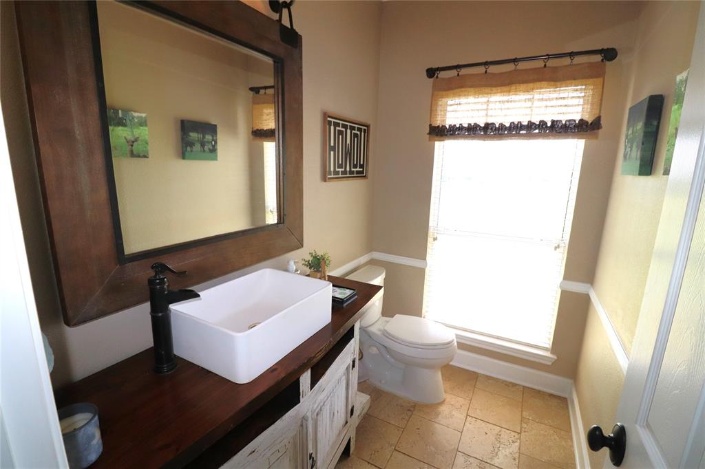 2642 Huddleston Road Sunset, TX 76270 - Photo 24 of 40 a bathroom with a sink a toilet and a mirror