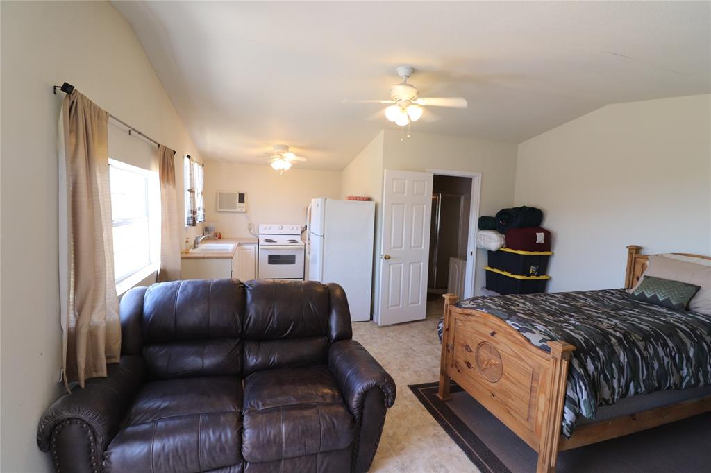 2642 Huddleston Road Sunset, TX 76270 - Photo 35 of 40 a bedroom with a bed and a chandelier