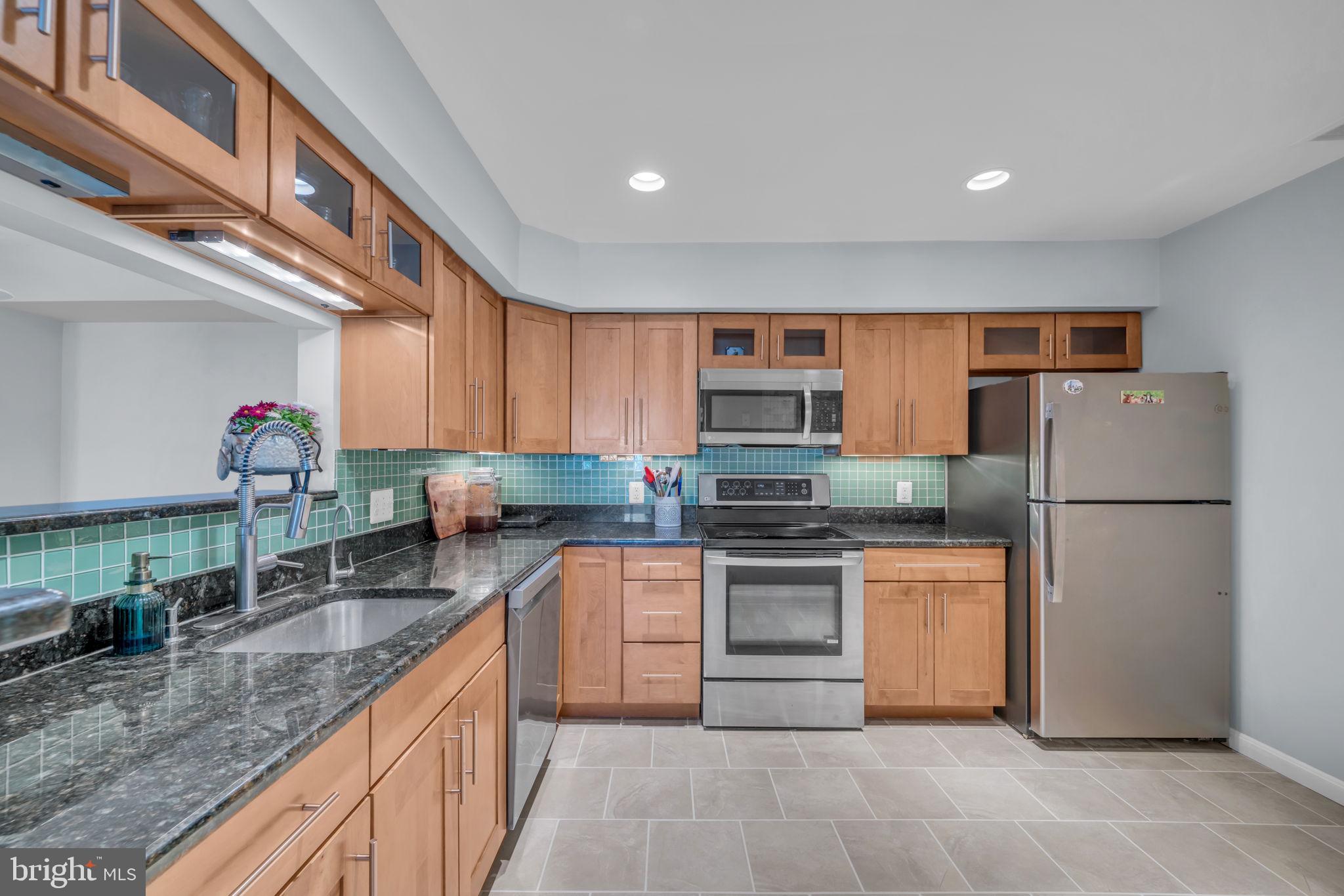 2233 Lovedale Lane, Unit L Reston, VA 20191 - Photo 9 of 18 a kitchen with stainless steel appliances granite countertop a refrigerator a stove top oven a sink and dishwasher